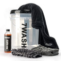 7WASH Starter Wash kit featuring a transparent wash bucket with black branding, one 500ml bottle of premium auto wash shampoo, a grey microfiber wash mitt, a grey drying towel, and a large black microfiber cloth.