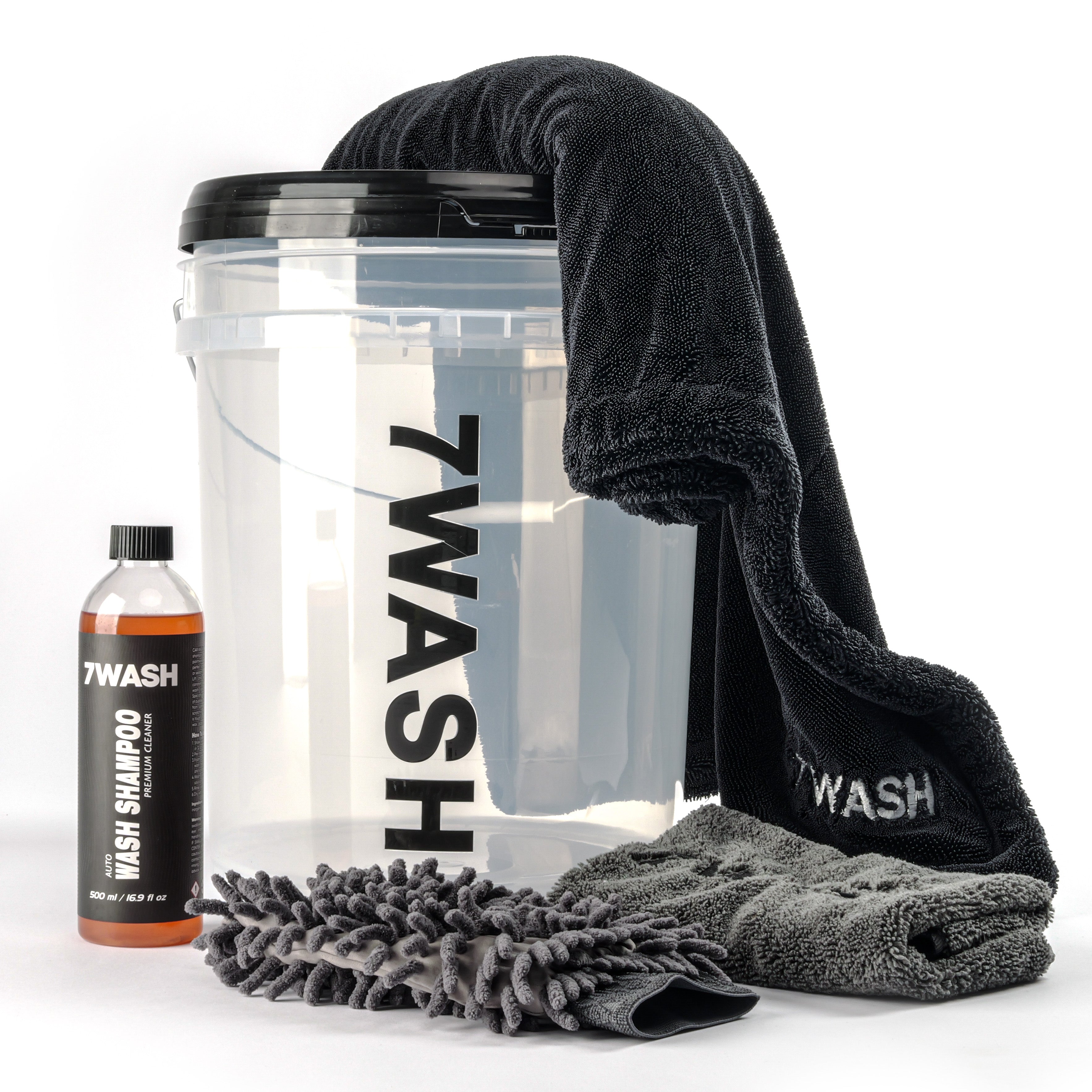 7WASH Starter Wash kit featuring a transparent wash bucket with black branding, one 500ml bottle of premium auto wash shampoo, a grey microfiber wash mitt, a grey drying towel, and a large black microfiber cloth.
