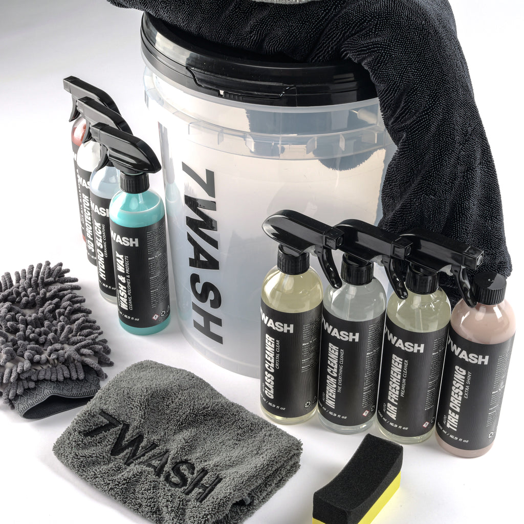 7WASH car detailing kit including a wash bucket, microfiber towels, wash mitt, foam applicator, and eight cleaning spray bottles featuring shampoo, wax, and interior cleaners.