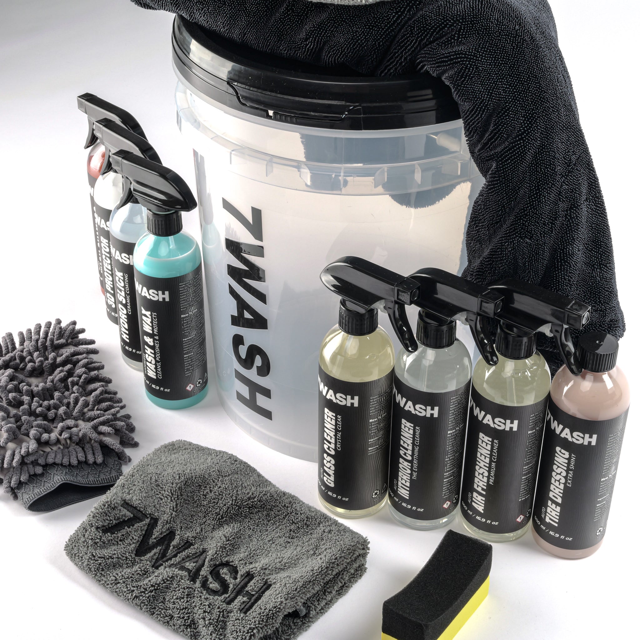 7WASH car detailing kit including a wash bucket, microfiber towels, wash mitt, foam applicator, and eight cleaning spray bottles featuring shampoo, wax, and interior cleaners.