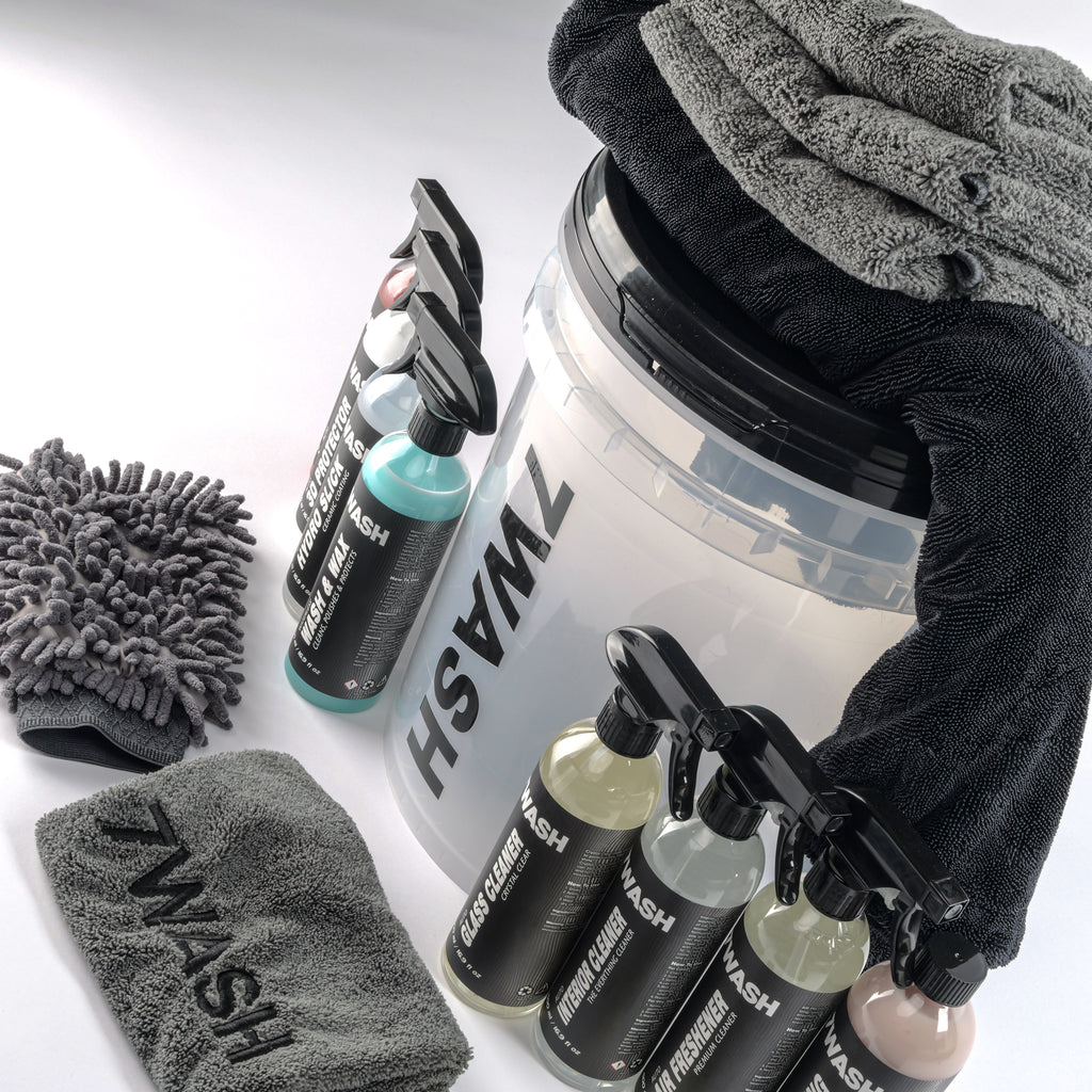 7WASH car detailing kit including a wash bucket, microfiber towels, wash mitt, foam applicator, and eight cleaning spray bottles featuring shampoo, wax, and interior cleaners.