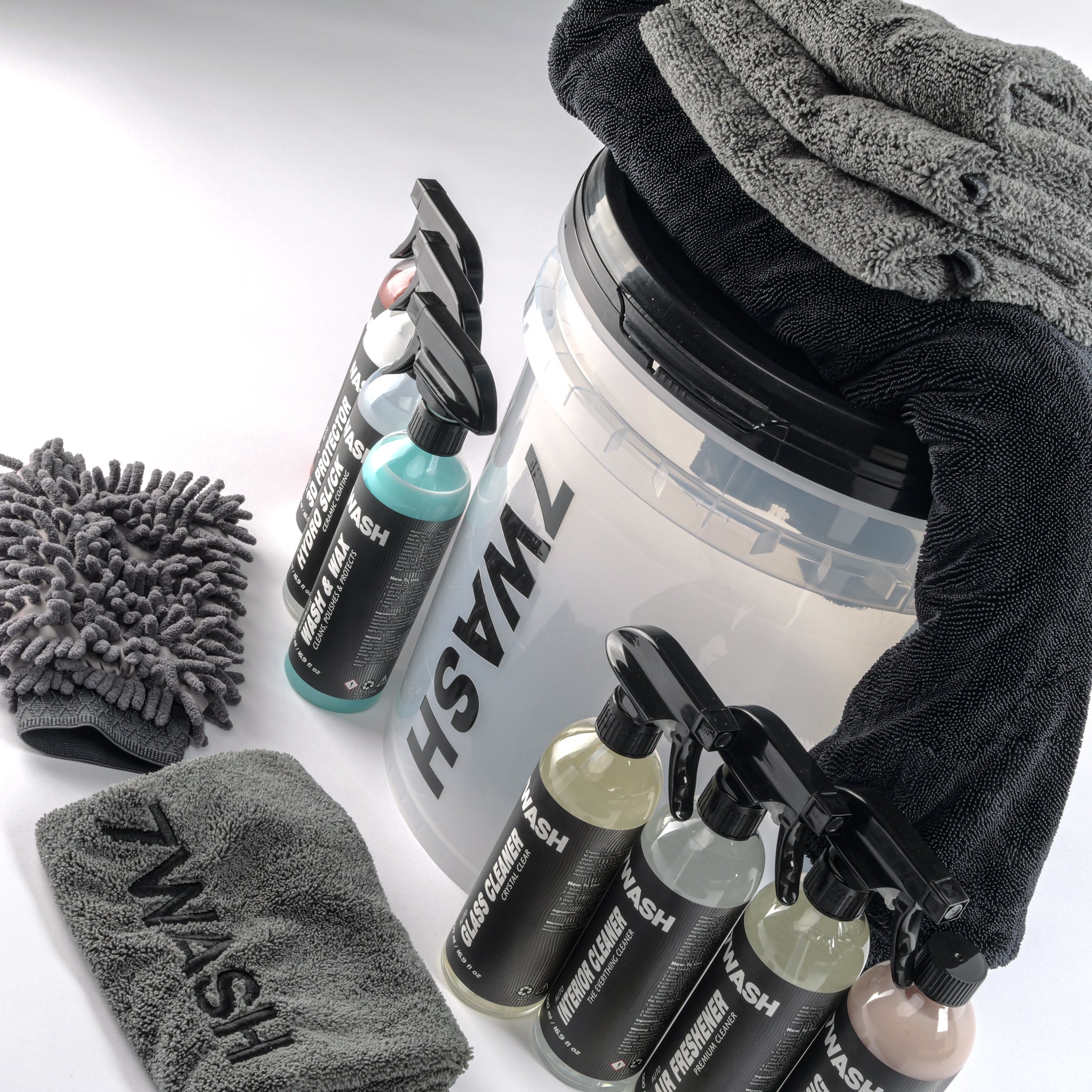 7WASH car detailing kit including a wash bucket, microfiber towels, wash mitt, foam applicator, and eight cleaning spray bottles featuring shampoo, wax, and interior cleaners.