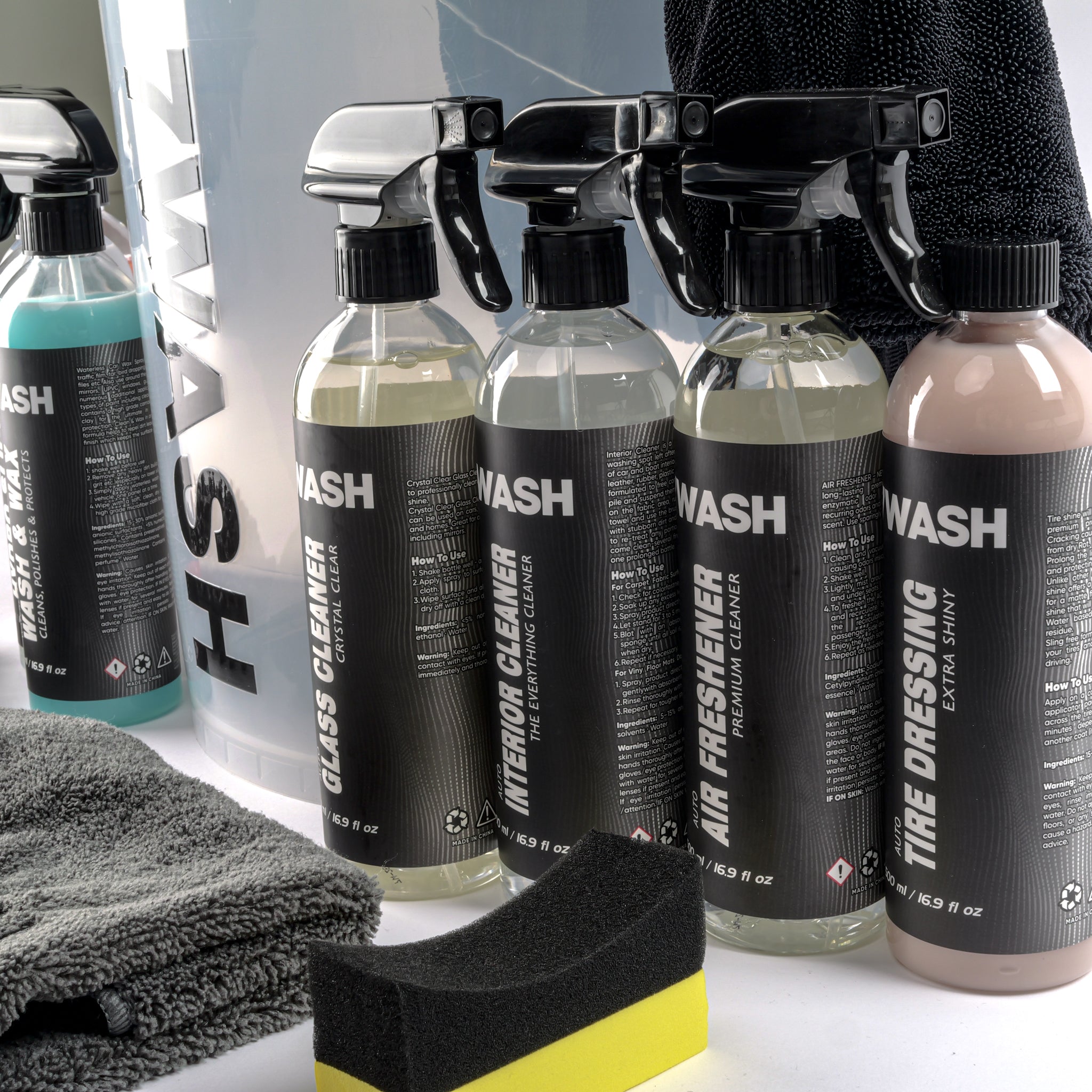 7WASH car detailing kit including a wash bucket, microfiber towels, wash mitt, foam applicator, and eight cleaning spray bottles featuring shampoo, wax, and interior cleaners.