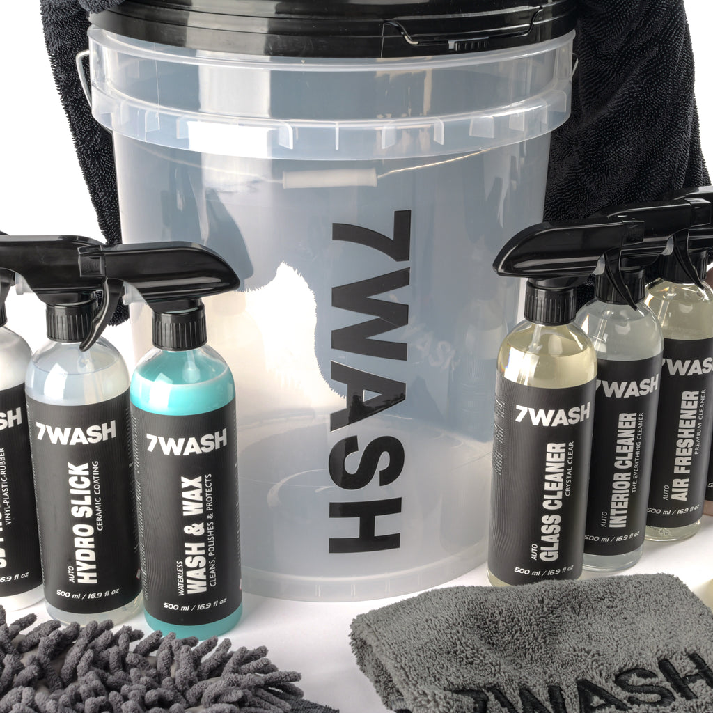 7WASH car detailing kit including a wash bucket, microfiber towels, wash mitt, foam applicator, and eight cleaning spray bottles featuring shampoo, wax, and interior cleaners.
