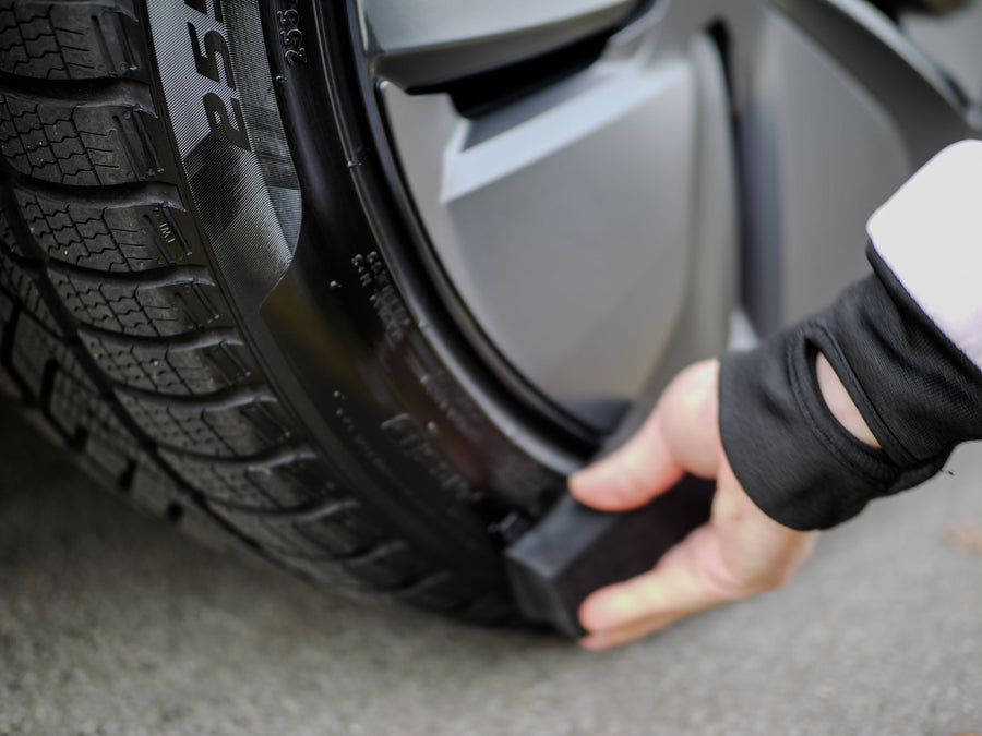 Working the dressing evenly into the tire sidewall with a pad